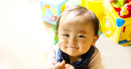 happy pretty baby boy with smile and white with toy background and copy space.boy looking at the camera.の写真素材