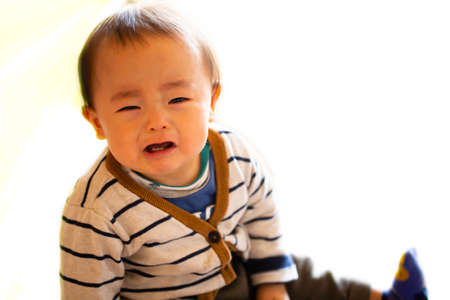A small child or a baby cries, isolated on white background and copy space.He appeals to mother for sorrow.の写真素材