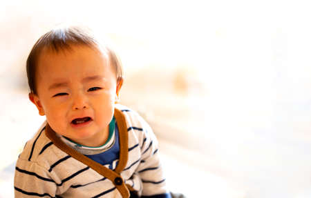 A small child or a baby cries, isolated on white background and copy space.He appeals to mother for sorrow.の写真素材