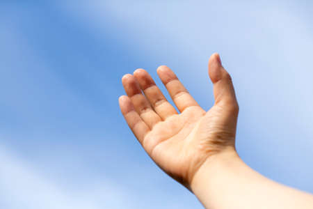 Woman's or man's hand turned up to the blue sky and copy space.の写真素材