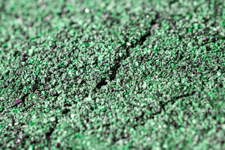 Dried cracked or rich earth soil ground texture background. crack pattern of sunny rich earth soil and copy space and green.の写真素材