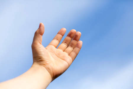 Woman's or man's hand turned up to the blue sky and copy space.の写真素材