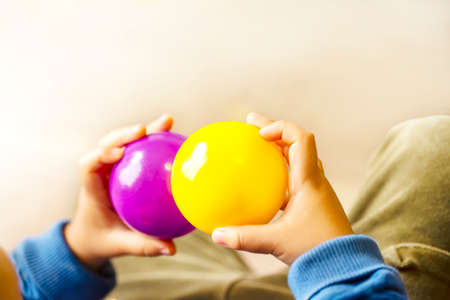 Hands holding purple and yellow two balls and copy space.の写真素材