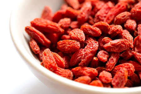 white bowl of red dried goji berries isolated on white background and copy space. close up.の写真素材