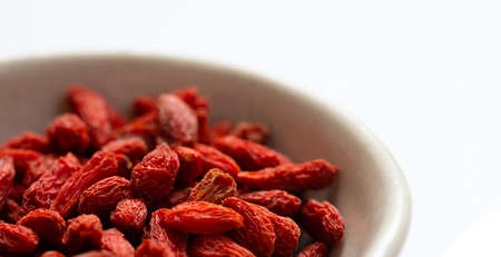white bowl of red dried goji berries isolated on white background and copy space. close up.の写真素材