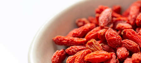white bowl of red dried goji berries isolated on white background and copy space. close up.の写真素材