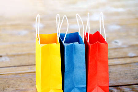 Colorful paper bags on the table on a wooden backgrounds and close up. red, blue, yellow.の写真素材