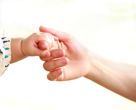 Family scene , close up parent and baby holding hands together and white background with copy space.の写真素材