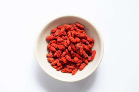 white bowl of red dried goji berries isolated on white background and copy space, top view.の写真素材