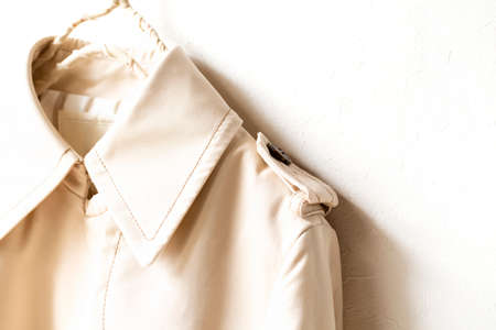 A beige trench coat isolated over white and close up.の写真素材