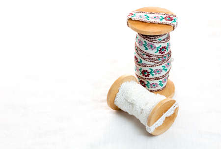 Vintage lace on the wooden bobbin on white background and copy space.の写真素材