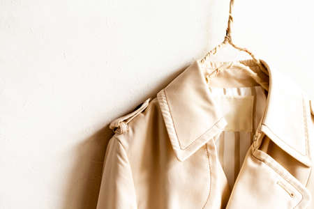 A beige trench coat isolated over white and close up.の写真素材