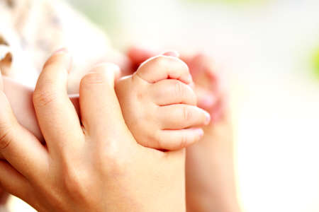 Family scene , close up parent and baby holding hands together and white background with copy space.の写真素材
