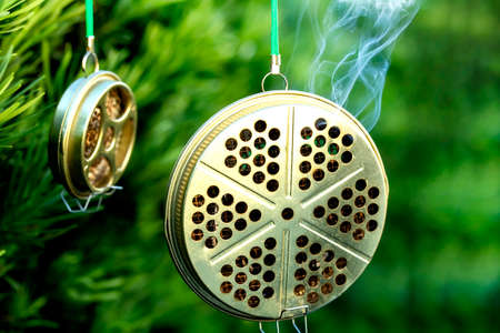 container for mosquito-repelling incense on green background and copy space.の写真素材