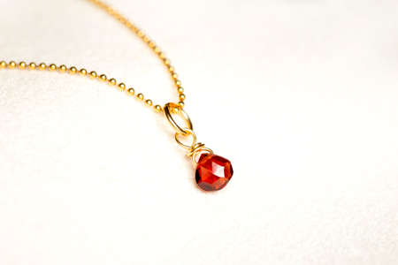 golden necklace with the stone of the chestnut brown on white background.close up.の写真素材