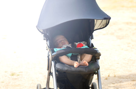 Sweet little baby sleeping in stroller in summer or autumn outdoors and copy space.の写真素材