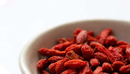 white bowl of red dried goji berries isolated on white background and copy space. close up.の写真素材