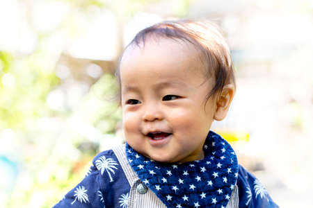 Portrait of happy joyful beautiful little boy isolated on outside background and copy space.の写真素材
