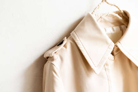 A beige trench coat isolated over white and close up.の写真素材