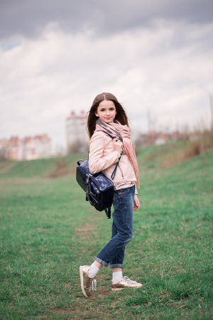 Happy pupil with backpack walking to school in the spring or summer outdoor..の写真素材