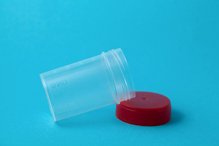 pathology jar test containing for urine sample isolated in blue backgroundの写真素材