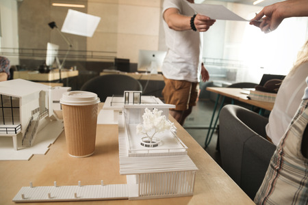 cup of coffee on the table in office. Business lunch. Man give document to another manの写真素材