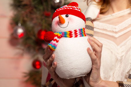 New Year young Girl with holiday mood in Christmas interior with tree and funny decorative toys. Beautiful woman portrait in sweater and decor in arms. Copy free space for text. 2017 trendの写真素材