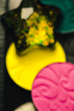 Star and Palette of shadows for make-up with sequins and glitter. Brown, green, yellow, black and pink colours.の写真素材