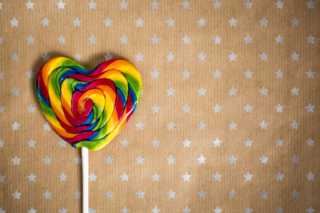 Tasty round candies on wooden stick on paper craft background with stars. Copy space for text and design. Food conceptの写真素材