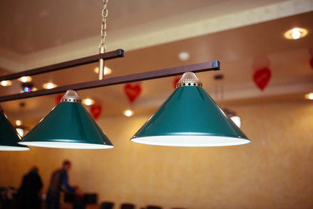 Billiard lamps above the billiard table are ready for the gameの写真素材
