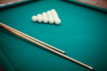 Billiard balls and two Cues in the form of a triangle on the billiard table are ready for the game