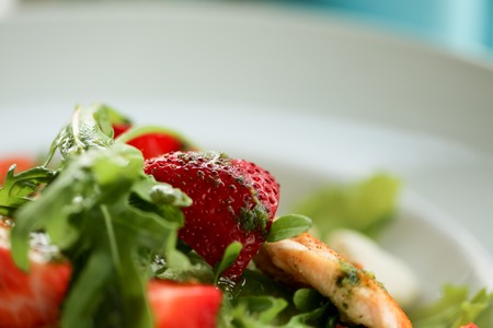 salad with salmon on white plate. Lifestyle healthy eating Food photo concept. macro strawberry in focus.の写真素材