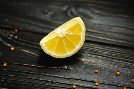 black wooden background. Blackboard. Grunge texture with yellow slice lemon. Copy space for text and design. Top view wood with Food. Vegetables for vegeterianの写真素材