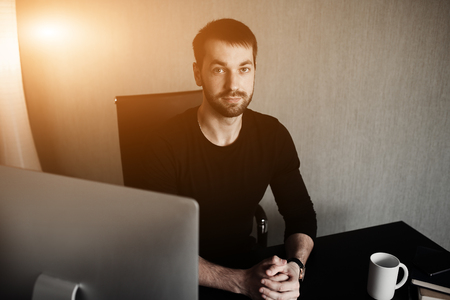 Smart businessman at workplace in office holding his head on hands. Sleepy worker early in the morning after late night work. Bisnanse and finance concept. Flare for Design and copy space.の写真素材