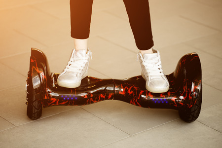 Girl rides on gyroscooter. Child's legs in sneakers on on mini segway.の写真素材