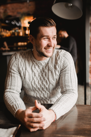 Man in cafe. lifestyle portrait of cute boy in sweater. Rustic styling.の写真素材