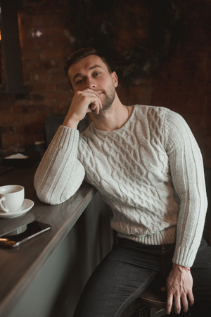 Man in cafe. lifestyle portrait of cute boy in sweater. Rustic styling.の写真素材