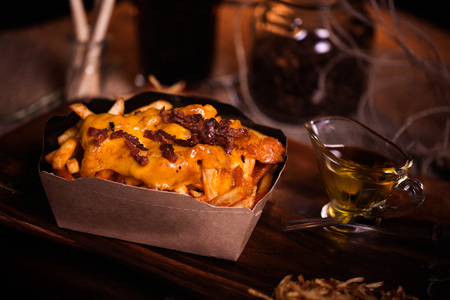 Fries food photo. Street food. Unhealthy tasty grilled french fries with cheese and bacon in...
