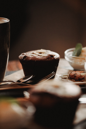 Close up food image of cup of coffee and dessert on the wooden table backgrouund in cafe. Trend warm toning. Photo with a small depth of field.の写真素材