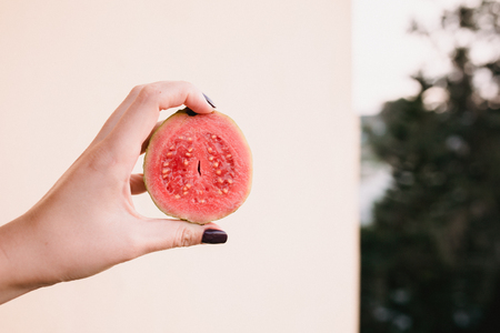 Close up food image of slised dragon fruit in woman's hand. Travel inspiration photo with a small depth of field. Blur background with copyspace for design.の写真素材