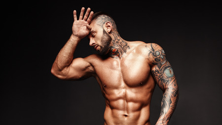 Banner image of sexy man with muscular body. Portrait of sexi male model. Hot macho, bodybuilder with muscle torso in abs poses on black background. 16 in 9 crop for design.の写真素材