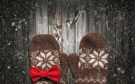 Brown mittens and spruce branches with snow on black wooden background. Holiday postcard design. Christmas and New Year concept with copy space.の写真素材