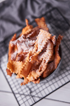 Brushwood - russian traditional cookies with powdered sugar. Food consept. Plate with hvorost on white marble background, Copyspace for text and design elements. Close up top view.の写真素材