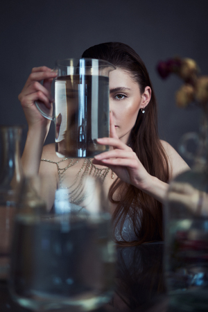 Beauty portrait of girl with water and reflections. Hight quality retouching photo. Fashion model.の写真素材