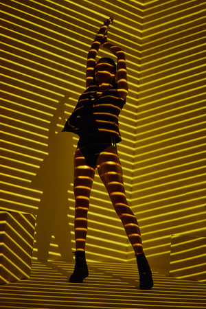 Beauty portrait of girl with light stripes and shadows in gold color. Hight quality retouching photo. Fashion glamour model.の写真素材