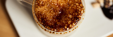 Banner size image of macro photo of hot latte with baked caramel crust. Food concept. Top view close up image of coffee.の写真素材