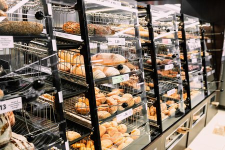 Different fresh bread, croissants, brezels on shelf in store with price. Market time. Food photo concept of choice bread on breakfast.の写真素材