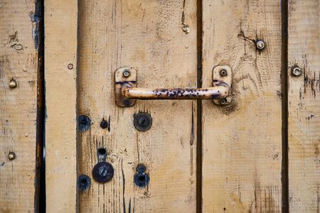 Background wooden texture. Hard old painted wall with doors knob in grunge style. Surface for design and text. Close up view.の写真素材