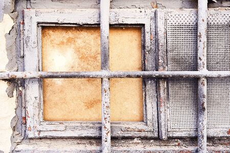 Background rust texture. Hard old painted grey wall with wooden window and lattice in grunge style. Surface for design and text. Close up view.の写真素材