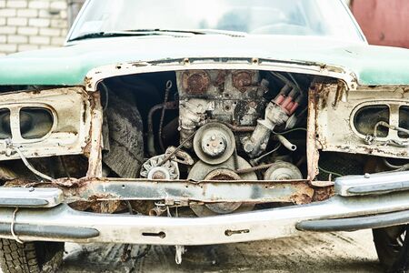Details of old car. Aged oldtimer vintage automobile. Spare parts of retro classic automobile. Disassembled car in a parking lot.の写真素材